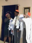 Rabbi and mother Muriel place his first tallit on Lorenzo.